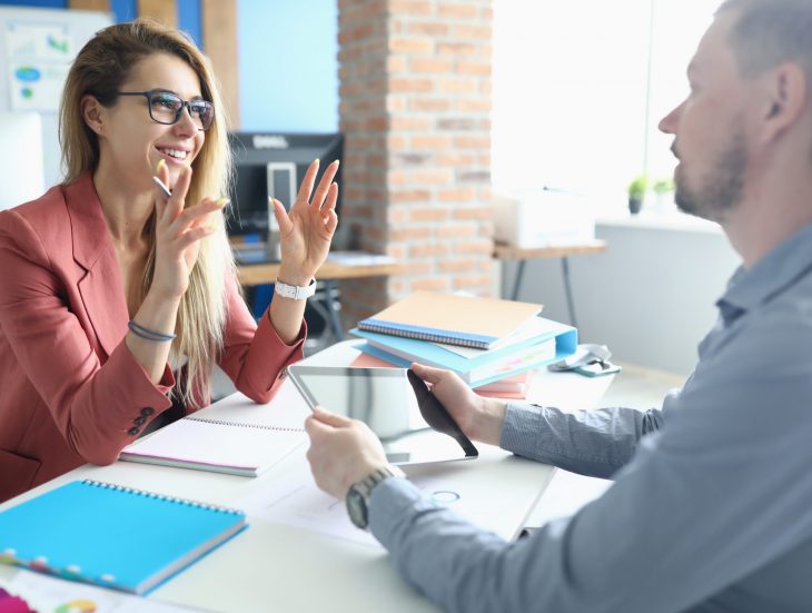 Two adult business people make work interview against office background